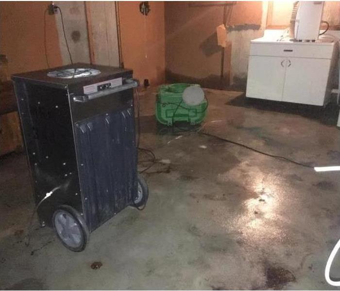 Wet floor in a utility room, air  mover and dehumidifier placed on affected area